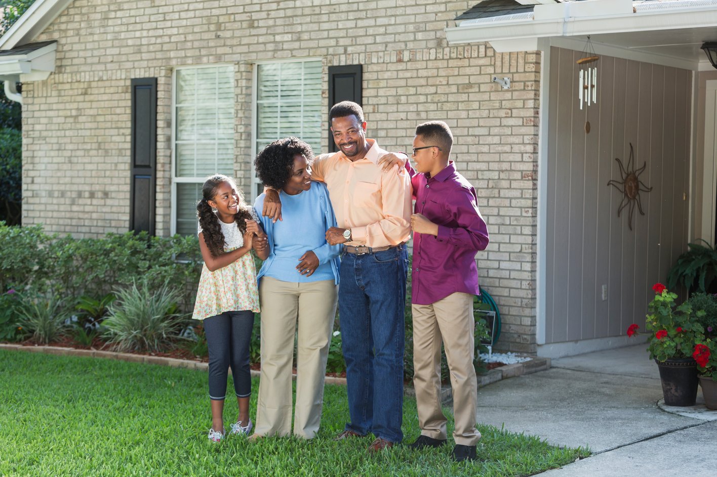 Family Standing Together Outside of a House