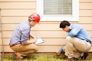 Contractors inspecting home before installing a radon mitigation system.